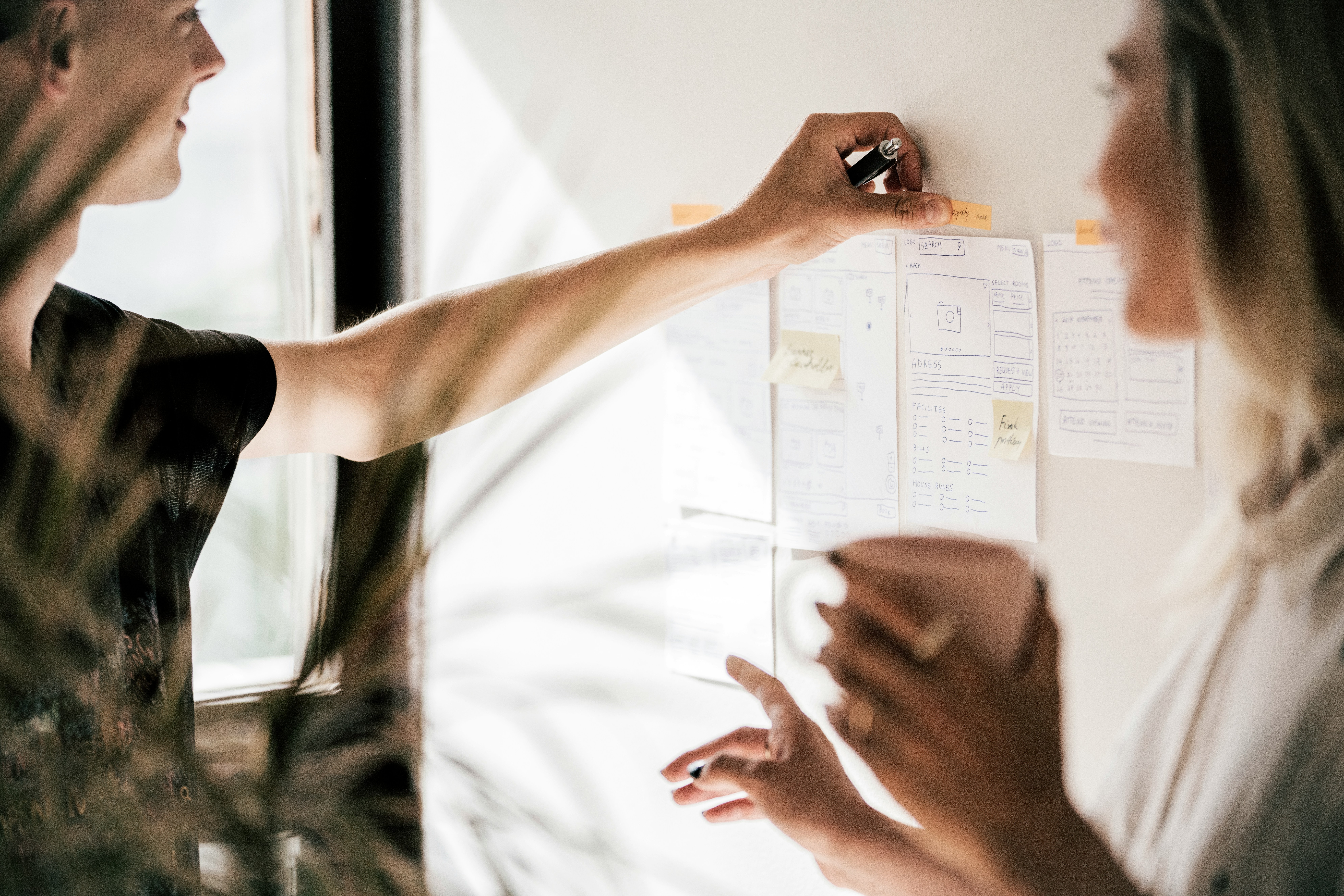 adomas-aleno--ySLeov8m_8-unsplash Person holding white printer paper on a white board.